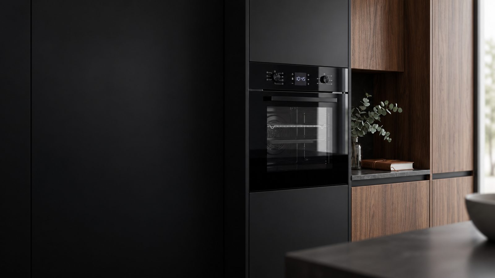 A built-in oven in a dark kitchen with walnut veneer